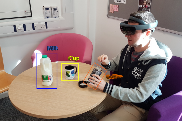 A man sat at a table making a cup of coffee using augmented reality technology