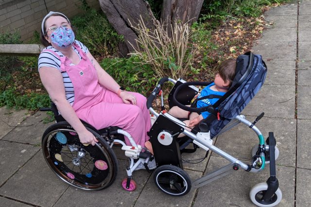 Person in wheelchair with pushchair attached to carry child